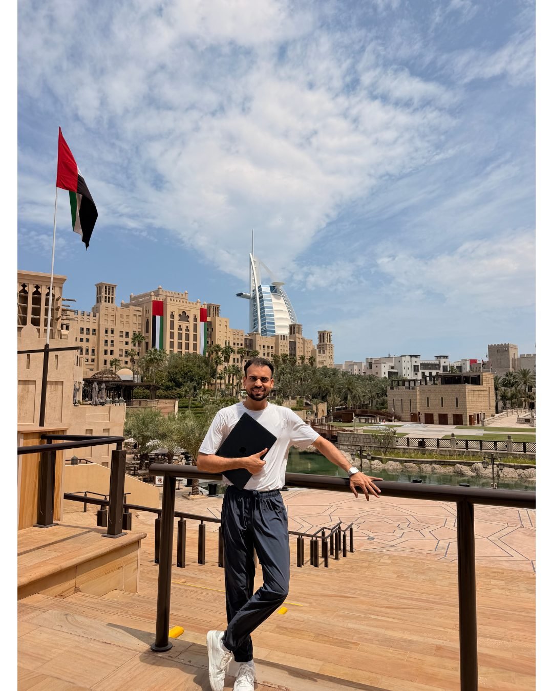 Shahbaz Khan with a laptop in front of Burj Al Arab