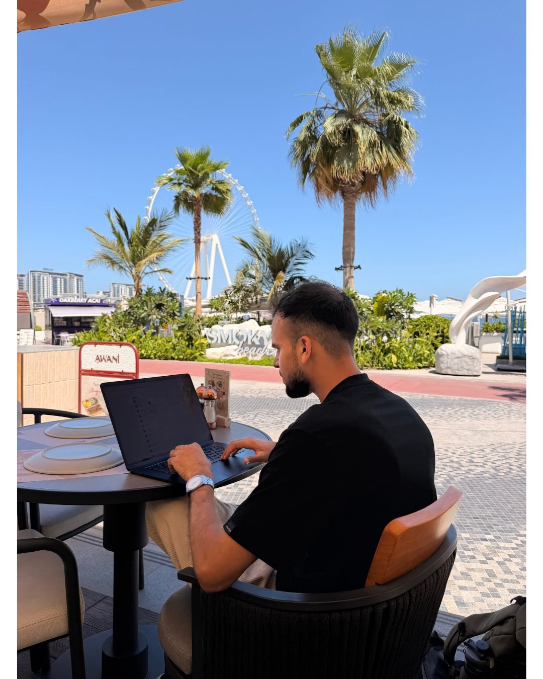 Working on a laptop by Ain Dubai